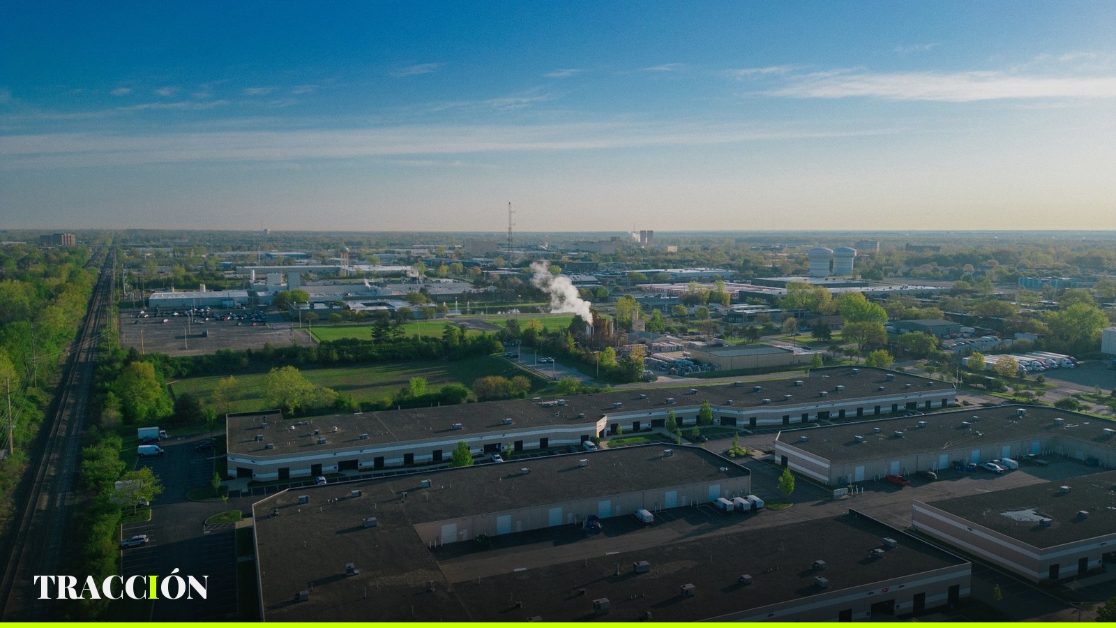 Vista aérea de un parque industrial con naves y estacionamientos