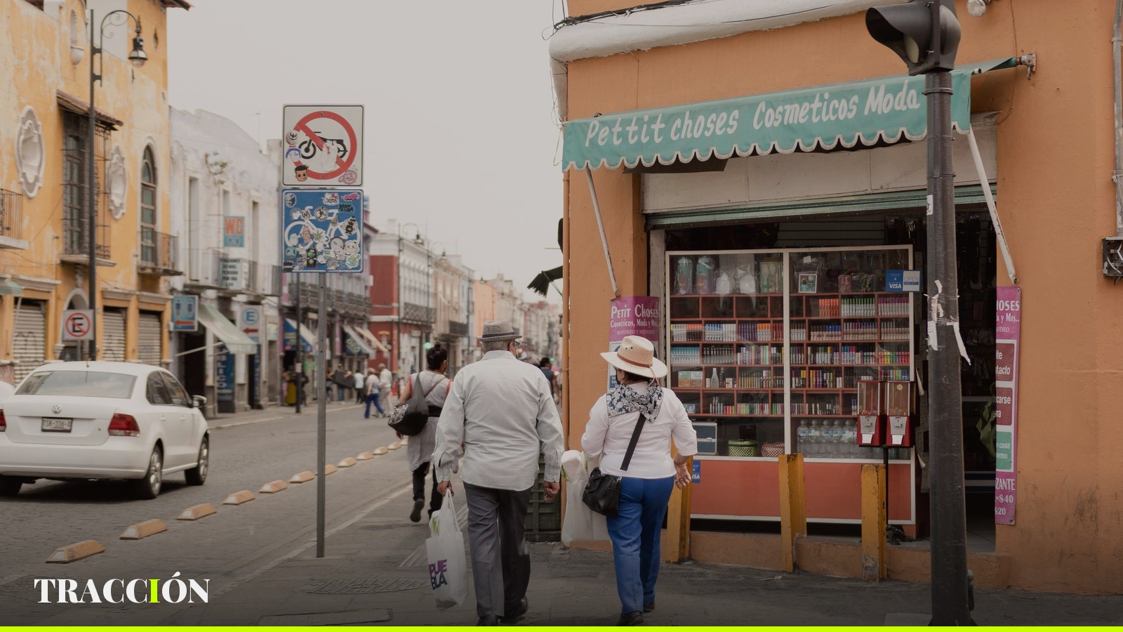 Personas caminando frente a una tienda en una calle comercial de Puebla